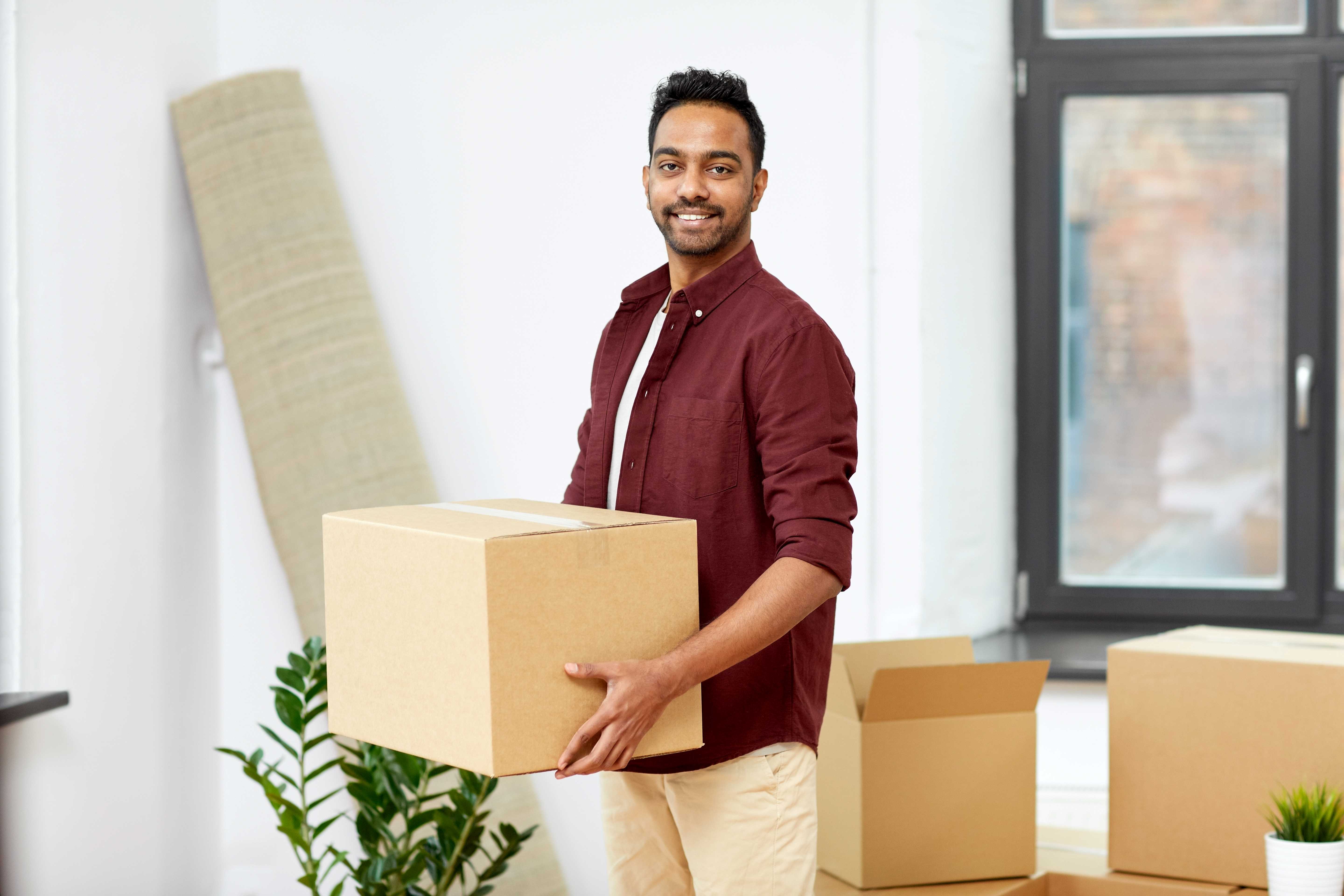 moving-people-real-estate-concept-happy-indian-man-with-boxes-new-home.jpg